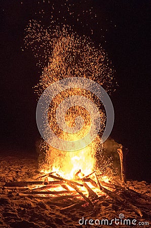 Hikers crowd around a beach bonfire at the end of the heaphy trail on New Zealands West Coast. Stock Photo