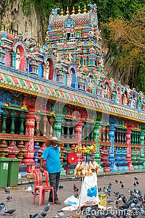 A huge flock of pigeons near the birdfeeder at the entrance to the Batu Caves Editorial Stock Photo