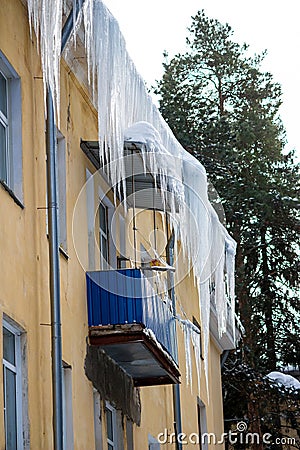 Huge icicles hanging over the balcony of a residential building Stock Photo