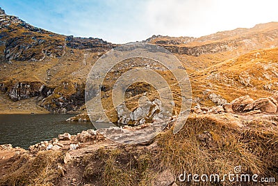 Huge lake in the mountains with a little house on the dock. Nice blue sky with some clouds. Shot in Romania, Transfagarasan Stock Photo