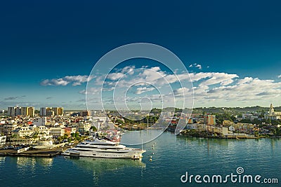 Huge motor boat in the port of Pointe-a-Pitre, with beautiful city on background Guadeloupe Stock Photo