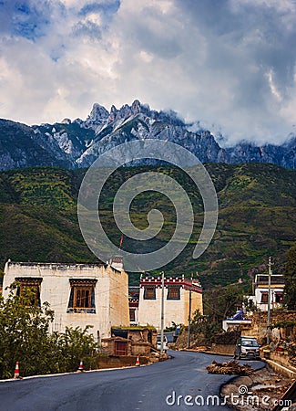 Huge mountain range towering over a traditional village in China Stock Photo