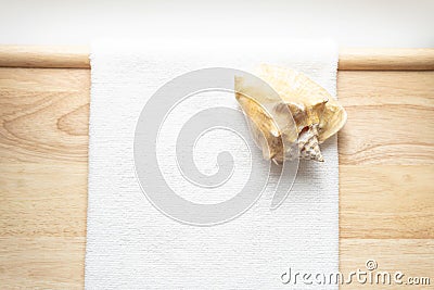 Huge natural seashell on a white towel on a wooden background Stock Photo