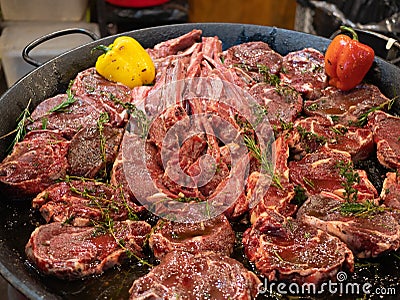 Huge pan with raw meat like ribs and steaks with spices and vegetables ready prepared for cooking Stock Photo