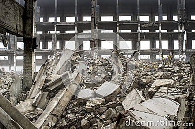 A huge pile of gray concrete debris from piles and stones of the destroyed building. The impact of the destruction Stock Photo