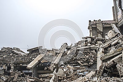 A huge pile of gray concrete debris from piles and stones of the destroyed building. The impact of the destruction Stock Photo