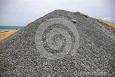 Huge pile of grey gravel on coast. Construction site material. Big gravel heap outdoor. Construction supply closeup. Stock Photo