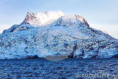 Huge Sermitsiaq mountain covered in snow with blue sea and small Stock Photo