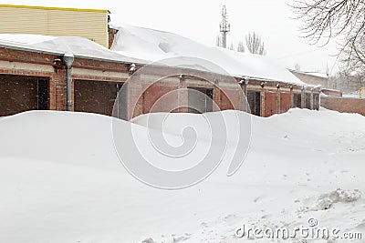 Huge snow banks near garage doors in winter during blizzard Stock Photo