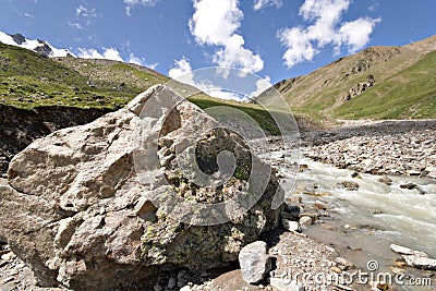 Huge stone near mountain river. Caucasus valley. Stock Photo