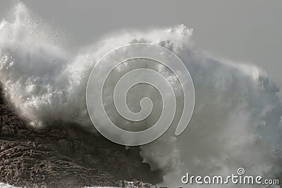 Stormy wave breaking over cliff Stock Photo