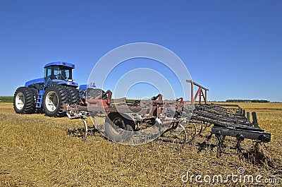 Huge tractor pulling a field cultivator Stock Photo