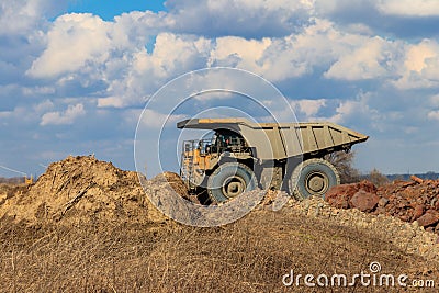 Huge yellow mining dump truck working in iron ore quarry. Mining industry Stock Photo
