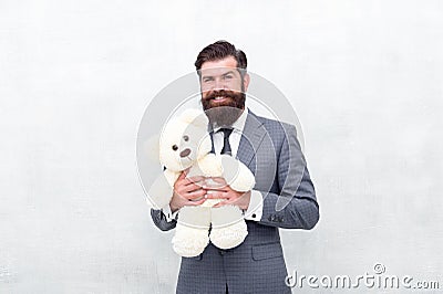 Huggably soft and ideal for cuddling. Happy businessman hold teddy bear toy blue background. Bearded man smile with soft Stock Photo
