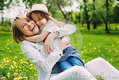 Hugging happy mother and daughter for a walk in the park On the green lawn. Stock Photo