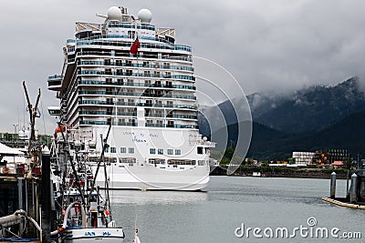 a hugh cruise liner with thousands of holiday makers and hundreds of cabins in the harbour of Juneau Stock Photo