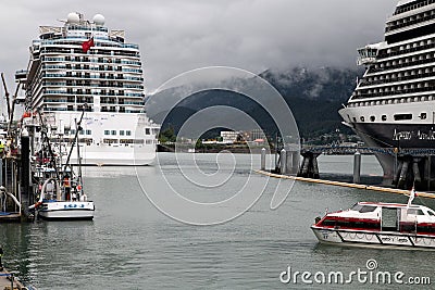 hugh cruise liners with thousands of holiday makers in the harbour of Juneau Stock Photo