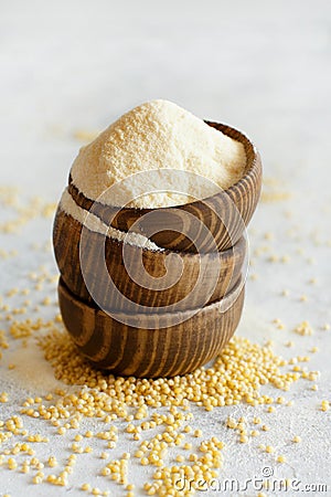 Hulled millet flour in wooden bowls and grain Stock Photo