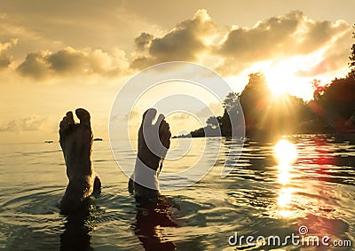 Human barefeet at beach on sunset in Koh Lipe Stock Photo