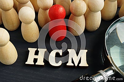 Human capital management HCM. Figurines and magnifying glass Stock Photo