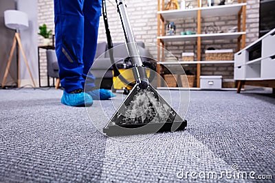 Person Cleaning Carpet With Vacuum Cleaner Stock Photo