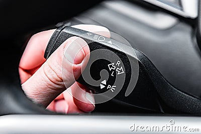 Human driving car and using turn signal switch. Stock Photo