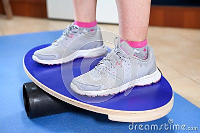 Human feet in jogging shoes standing on balance board Stock Photo