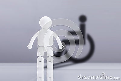 Human Figure On Desk Against Grey Background With Disable Icon Stock Photo