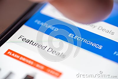 Human finger thumb over Electronics category button link on shopping app on smartphone screen closeup Stock Photo