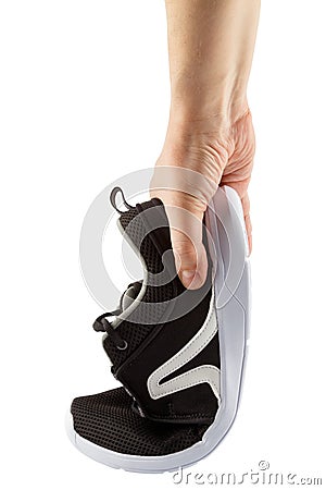 human hand bending lightweight black airmesh summer walking shoes isolated on white background Stock Photo