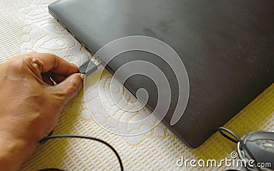 Human hand connecting Computer mouse connection cable plug-in the laptop keyboard. Network connection plugin internet of things Stock Photo