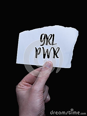 Human hand grasping a blank white sheet of paper with the bold black text 'GRL PWR' Stock Photo