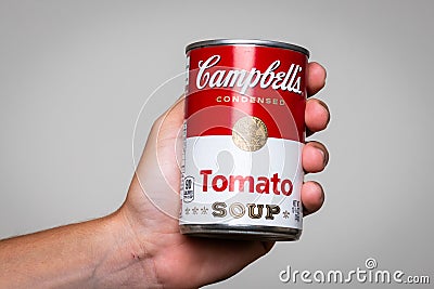 Human hand holding a tin can of Capbell`s Soup tomato soup Editorial Stock Photo