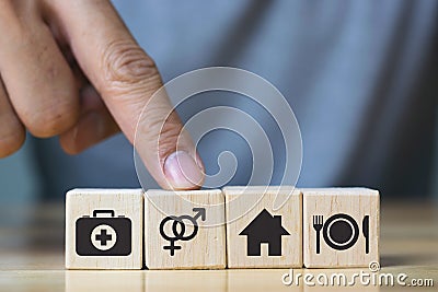 Human hand placing cube with food Clothing, housing, medicine, four basic human needs concept Stock Photo