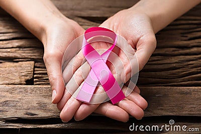 Human Hand Showing Pink Ribbon To Support Breast Cancer Cause Stock Photo