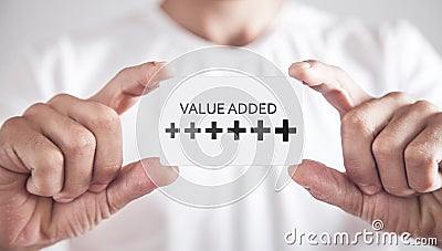 Human hand showing Plus symbols with a word Value Added. Profit, Benefit, Business Stock Photo