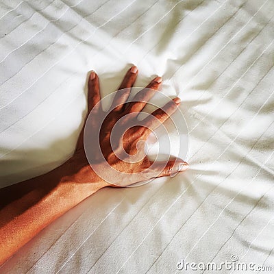 Hand of man on white blanket in bedtime Stock Photo