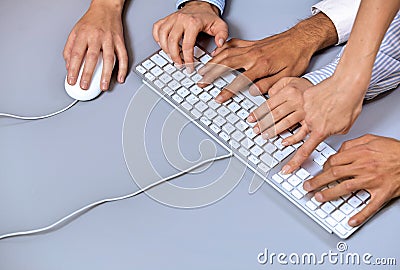 Human hands on computer keyboard with one hand using computer mouse Editorial Stock Photo