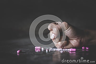 Human hands crushing pink pills on dark background. Stop drug addiction concept. International Day against Drug Abuse. Copy Space Stock Photo