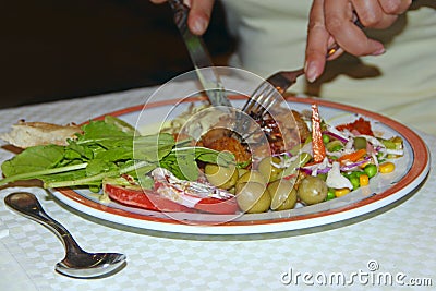 Human hands with fork and knife during eating vegetables and meat rissole Stock Photo