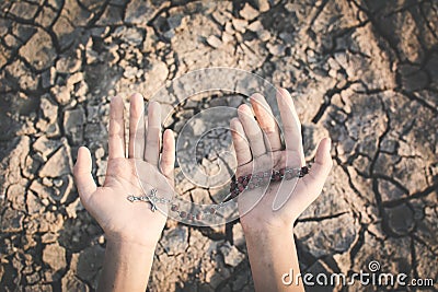 Human hands praying for the rain on cracked dry ground Stock Photo