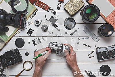 Human hands repair broken film camera repair and maintenance of photographic equipment concept Stock Photo