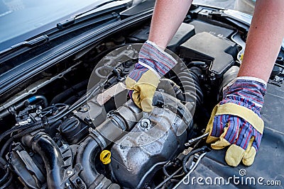 Human hands with wrenches in protective gloves upon car engine Stock Photo