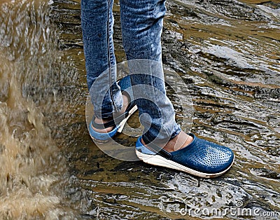 Human legs safely standing on a wet rock surface. Stock Photo