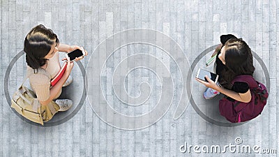 Human life in Social distance. Aerial top view with two student women with smartphone stand at grey pavement street road with Stock Photo