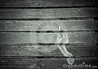 Human mud footprint on dark wooden plank floor with space. Stock Photo