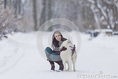 Human and Pet Relationships Concepts. Portrait of Lovely Caucasian Brunette Woman Along With Her Husky Dog Stock Photo