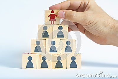 Human resources manager is selecting a female worker atop a pyramid made out of male employee icons Stock Photo