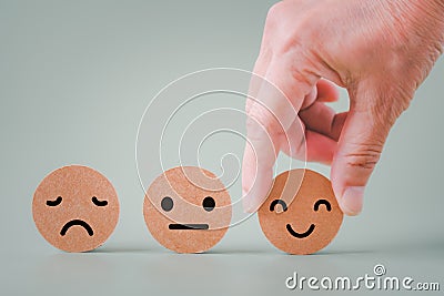 Human`s hand holding happy smile face on brown paper cut, satisfaction survey ,good feedback rating Stock Photo