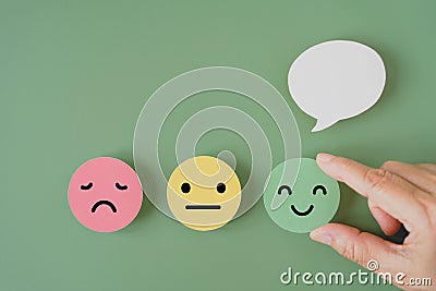 Human`s hand holding happy smile face paper cut with speech bubble on , satisfaction survey ,good feedback Stock Photo